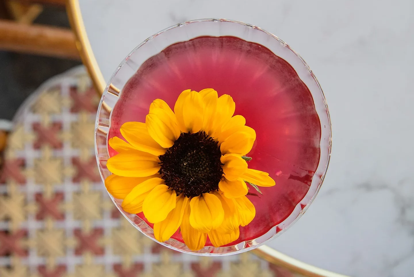A customized pink cocktail with a decorative sunflower served at Bisou, a sustainable bar in Paris.