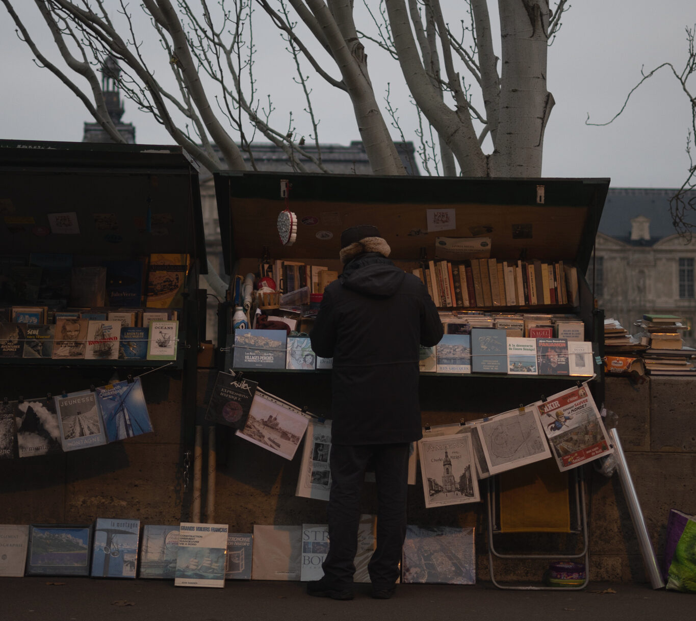 A Parisian bouquiniste in front of his stall.