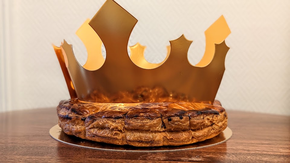 A galette des rois with a golden paper crown on top, bought on Epiphany from the Parisian bakery Atelier P1.