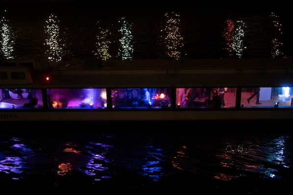 A cruise ship on the Seine on Valentine's evening with its colorful lights reflecting on the water.