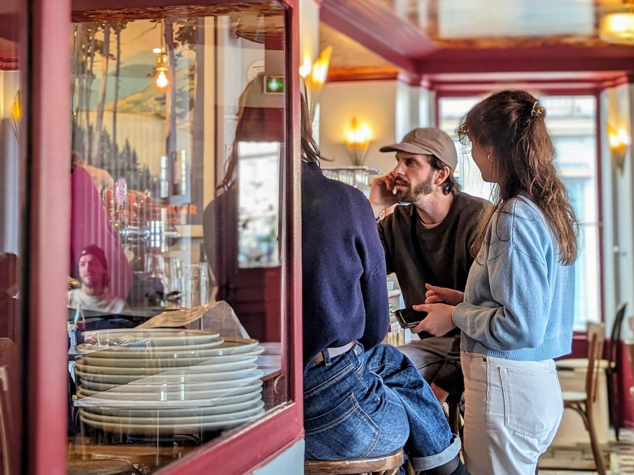 Friends sit around and talk at Café les Deux Gares in the 10th arrondissement in Paris.