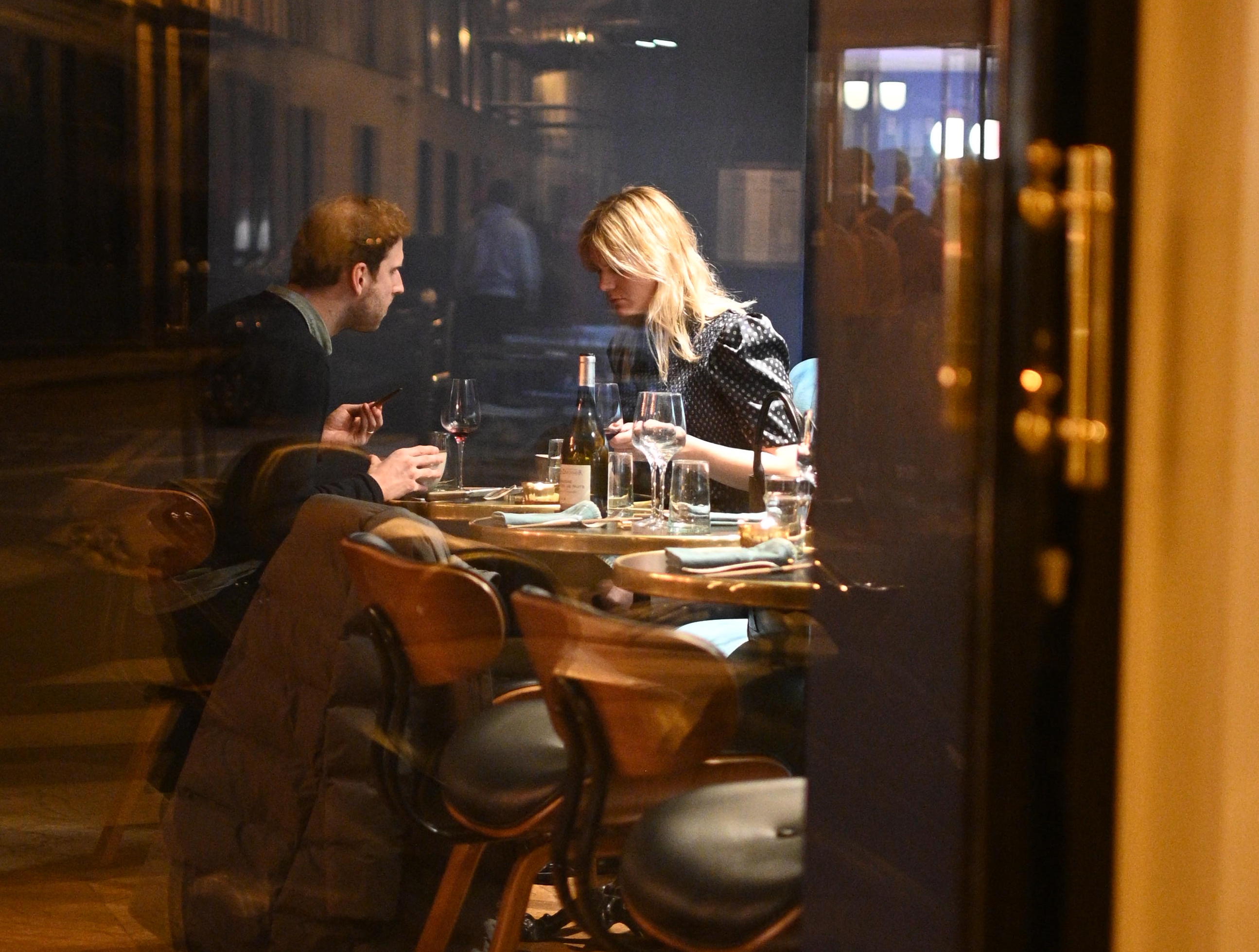 A couple is dining on the terrace of a restaurant in the 3rd arrondissement in Paris.