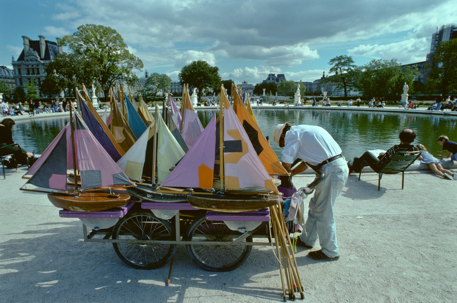 The vintage toy boat vendor with his cart in front of the the pond in the Jardin du Luxembourg.