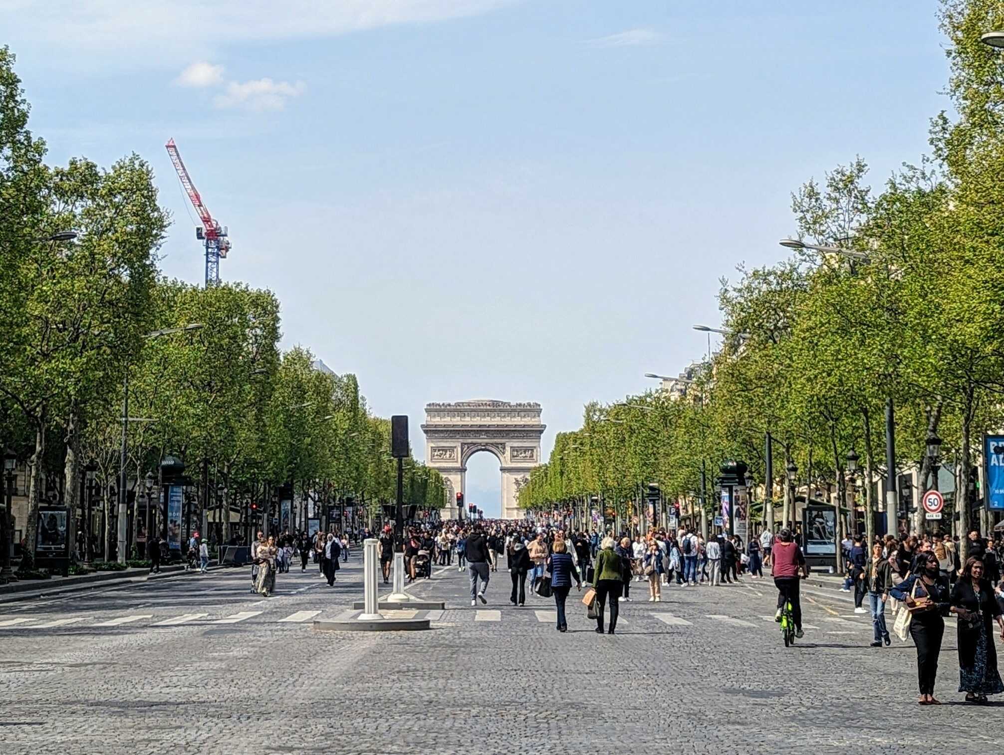 Pedestrians walking up the Champs-Elysées towards the Arc de Triomphe on a car-free Sunday.