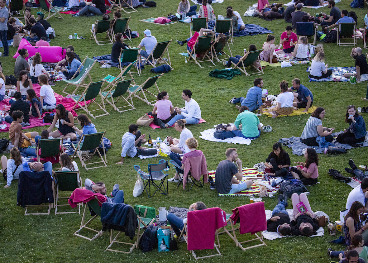 Parisians sitting on the grass at Parc de la Villette.