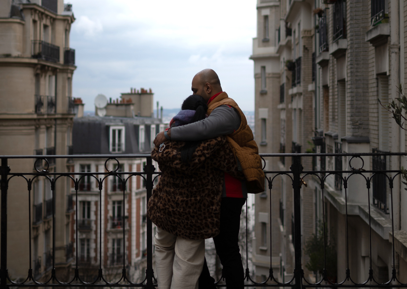 A couple sharing an intimate moment while enjoying the view on Paris from Montmartre.