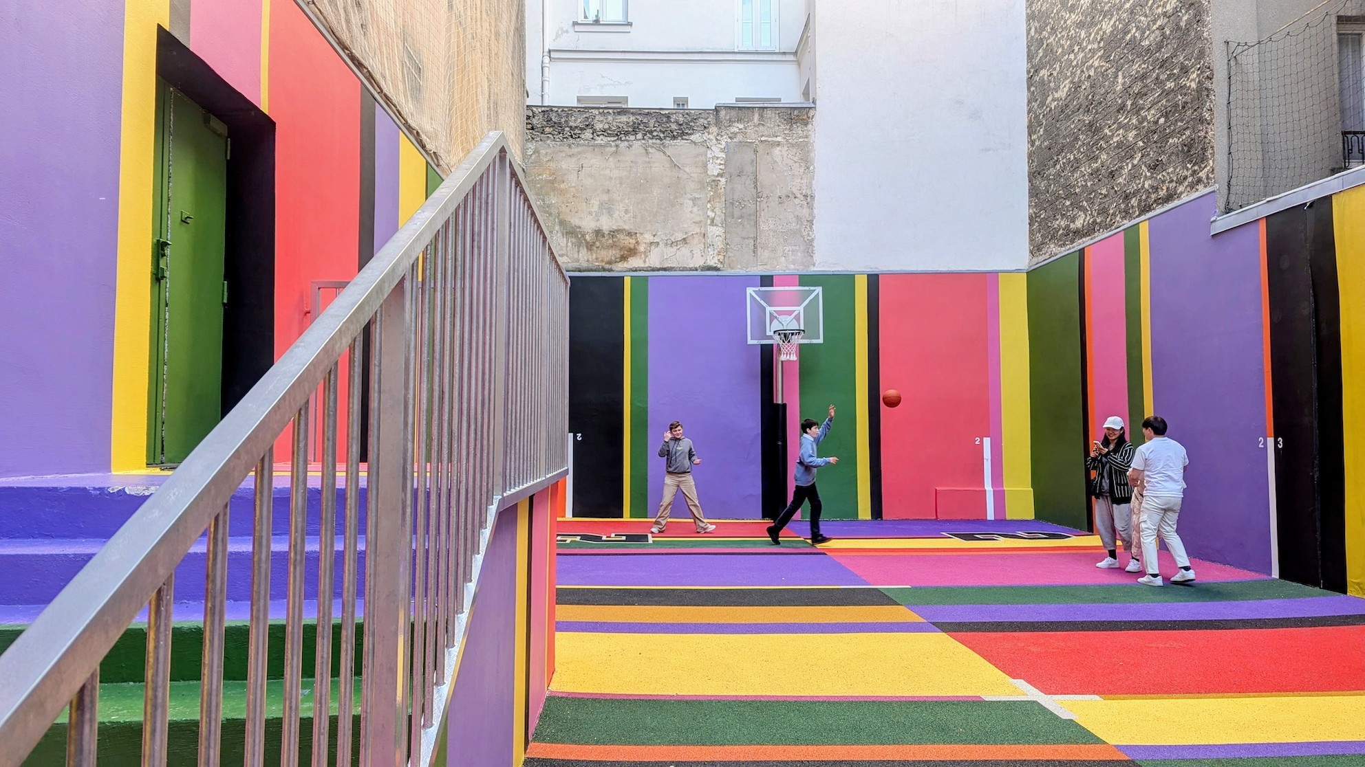 Local youths playing basketball on the colorful court in the 9th arrondissement in Paris.